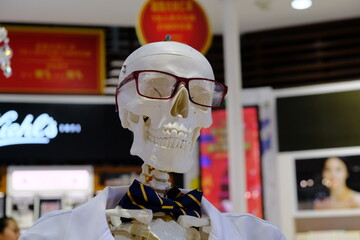 Fototapeta premium Bali, Indonesia - January 13 2020: A skeleton in glasses, a robe and a bow tie in the Duty free shop at the airport.