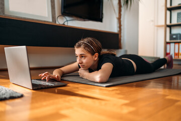 Fototapeta na wymiar Girl watching exercise tutorials online