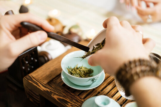 Master prepares Chinese tea leaves for home ceremony closeup image.