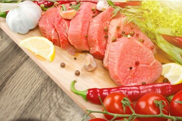 Raw meat slices and spices on cutting board