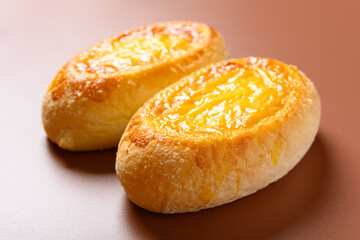 side view two pieces egg yolk flavor bread on brown background