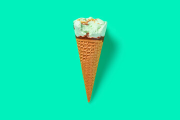 top view fresh hami melon and oats flavor ice cream cone with a bite on green background