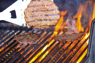 flipping hamburgers on a grill
