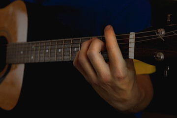 The guitar player plays, fingers on the guitar neck make a chord, close up.