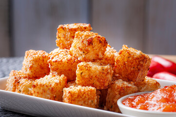 .Squares of tapioca and cheese served with pepper jelly. Wooden table. Space for text - Dice of...