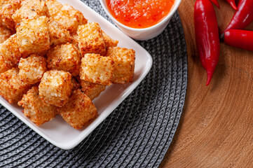 .Squares of tapioca and cheese served with pepper jelly. Wooden table. Space for text - Dice of tapioca. Top view.  Copy space