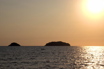 Scenic sunset on a tropical beach with an island in the background