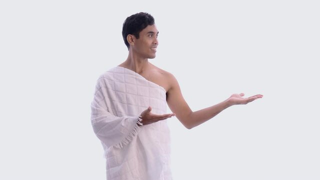 asian male with ihram presenting copyspace. hajj and umrah man concept