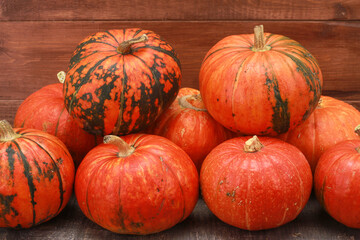 Heap of pumpkins against rustic wooden background. Autumn harvest, Halloween, Thanksgiving concept. Fall, holiday, festival, farm market