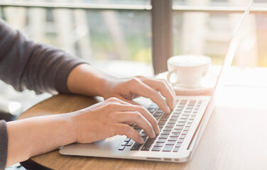 Fototapeta na wymiar close up of man typing on a laptop at cafe.