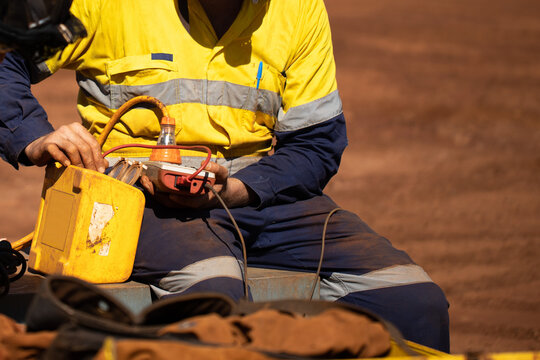 Safety workplace trained competent electrician setting holding electricity tester and conducting monthly safety testing tagging power residual-current device (RCD) prior use construction site Perth 