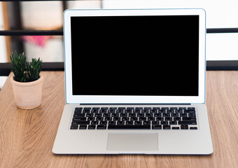 Fototapeta premium laptop with blank screen on table in cafe.