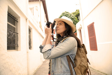 Woman visiting town taking pictures of architectural details with reflex camera