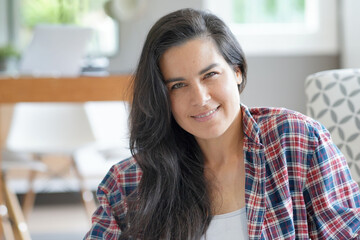 Portrait of beautiful and smiling dark-haired woman relaxing at home