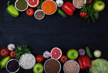Legumes, beans, mung bean, cereals, vegetables, fruits, greens on a black background. Vegetarian food. Healthy eating. Copy spaes.