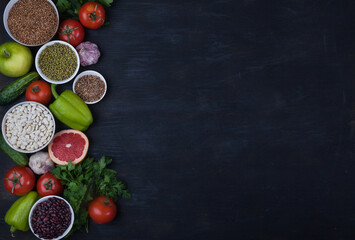Legumes, beans, mung bean, cereals, vegetables, fruits, greens on a black background. Vegetarian food. Healthy eating. Copy spaes. Flat lay.