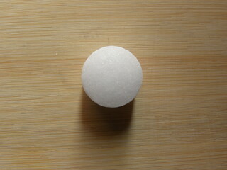 Small white color Naphthalene mothball on wood background
