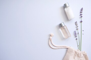 Composition with lavender and organic cosmetics In eco bag on blue background. Organic SPA beauty products for hair and body care. Flat lay, top view. SPA branding mockups.