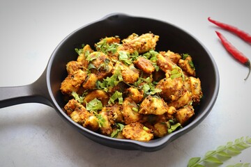 Fototapeta premium Stir fried taro roots. Arbi ki sabji, Taro roots masala curry. Arbi Masala. Garnished with coriander, red chili & curry leaves. copy space.