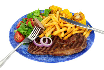 Grilled sirloin steak and French fries meal with fresh salad and sweetcorn cobs isolated on a white background