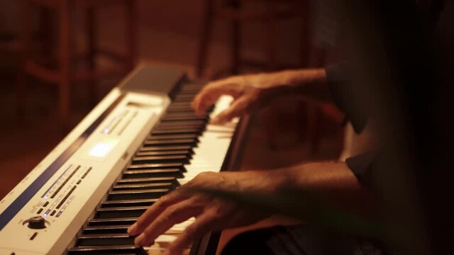 Keyboardist performs during wedding ceremony reception. Close up of hands. 