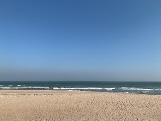 View of the beach by the sea under the clear sky