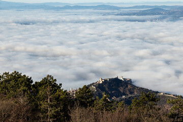 An aerial view of Assisi town and St.Francis church over a sea of fog