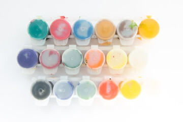 jars with gouache paints on a white background