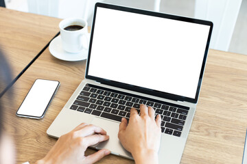 Fototapeta premium computer,cell phone mockup image.hand woman work using laptop texting mobile.blank screen with white background for advertising,contact business search information on desk in cafe.marketing,design