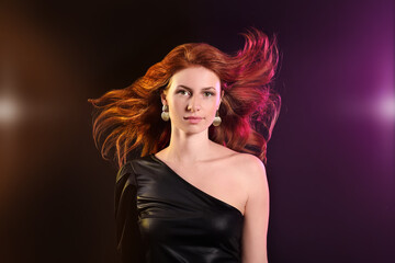 Beautiful young redhead woman on dark background