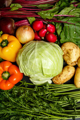 Top view of fresh assorted vegetables: cabbage, beetroots with haulm, potatoes, peppers