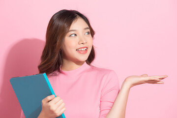 Young Asian woman doing business style poses in front of pink studio background