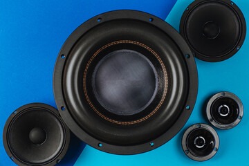 Car audio, car speakers, black subwoofer on a blue-light blue background. Close up