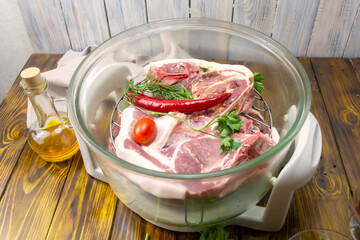 Fresh meat in an electric convection oven awaits cooking. Tomato, red pepper, parsley, oil. A delicious food recipe. Selective focus, close-up