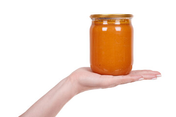 Hand with orange squash and carrot sauce preserve. Isolated on white background.