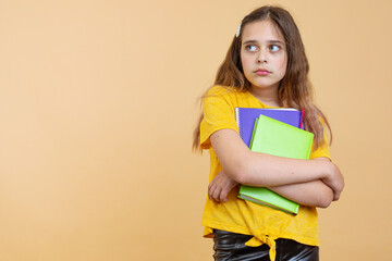 Prepare hard examen concept. Thoughtful puzzled smart clever minded confused crying little girl holding textbook notebook with formula in hand isolated bright background