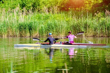 Two girls floating in a canoe on the river

