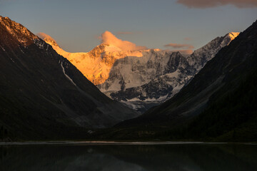 Obraz premium Belukha peak at sunset is reflected in the mountain lake AK-Kem