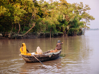Bangladesh local people on wooden row boat in river with mangrove forest. Dhaka.