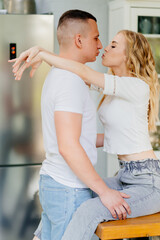 pair of lovers kissing and hugging in kitchen. 
