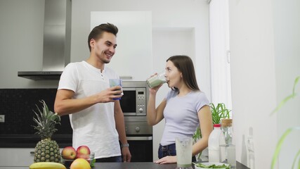 Young family in the morning drinking smoothie from vegetables of fruits with milk for the breakfast they have a healthy life and body