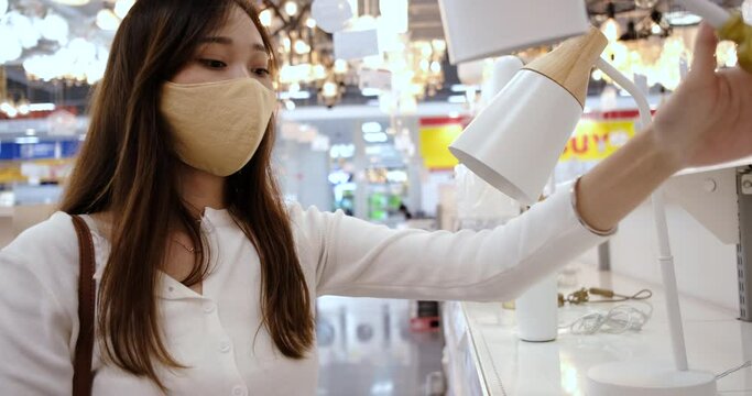 Young asian woman wearing mask shopping reopening store.