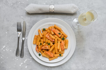 Penne pasta or Italian rigatoni with langoustines and  tomato sauce in white plate top view. seafood pasta recipe
