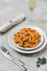 Penne pasta or Italian rigatoni with langoustines and  tomato sauce in white plate top view. seafood pasta recipe