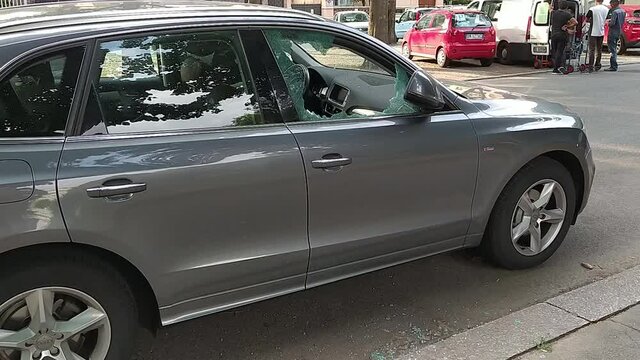 Turin,Italy.July 2020. A car has been broken into: the front right window is reduced to tiny splinters, some are on the pavement, others scattered on the dashboard. Rest of the glass is full of cracks