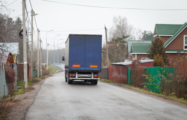 Lorry goes on empty rural road at day