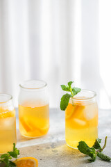 Fototapeta na wymiar Orange iced tea with mint on concrete background. Refreshment beverage for summer hot days.