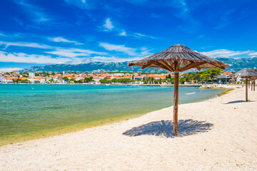 Adriatic sea shore in Croatia on Pag island, parasol on beautiful sand beach in town of Novalja

