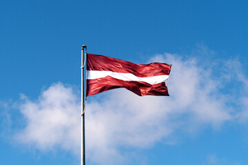 Flag of the Republic of Latvia. Flag of Latvia against the blue sky. Copy space.