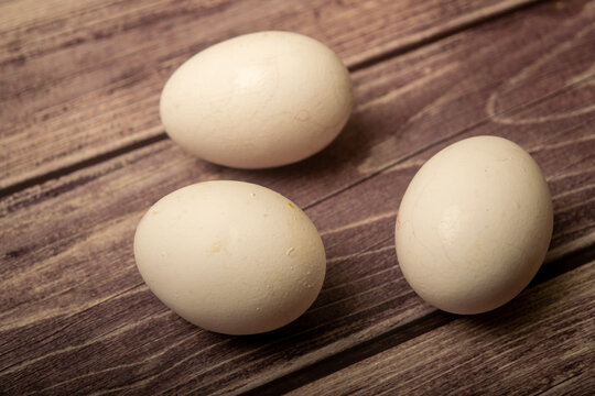 White chicken eggs on a wooden background. Close up.